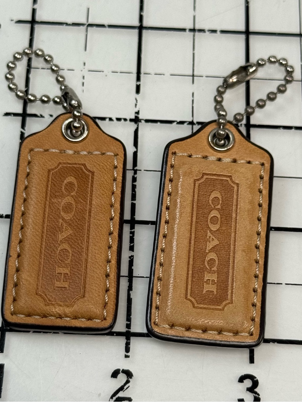 Coach two small Tan Leather Hang Tag Keychain Set. 2 by 1 inches. One with wear - Picture 2 of 5